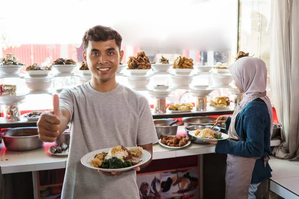 Portrét mladého muže a muslimky pracující jako tradiční prodavačka potravin — Stock fotografie