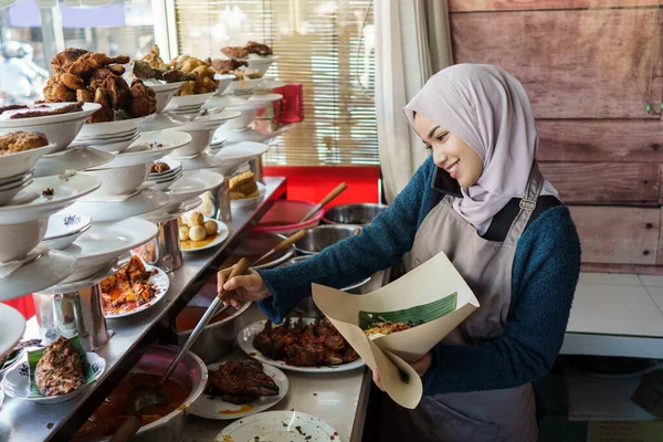 Retrato de uma jovem muçulmana embalando comida Padang — Fotografia de Stock