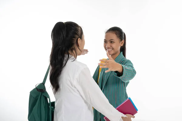 Zwei Studenten treffen Freund, der Tasche und Bücher in traditioneller Kleidung trägt — Stockfoto