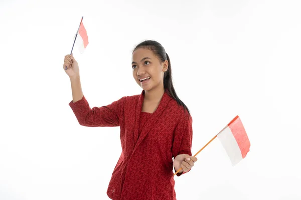 Индонезийская женщина захватила красный и белый флаг. Носить кебайю — стоковое фото