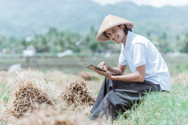 Agricultores masculinos usan almohadillas mientras están sentados en los campos de arroz — Foto de Stock