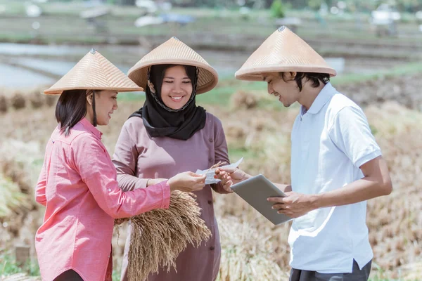 Grupo de agricultores con un sombrero que sostiene la cosecha y las tabletas — Foto de Stock