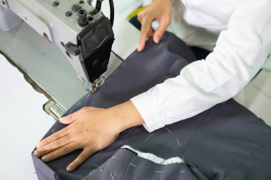 Kumaş bir terzi tarafından dikiş makinesi kullanılarak dikilmiştir.