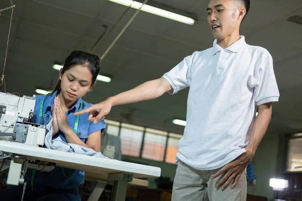 Supervisor masculino con una mano puntiaguda reprende a una sastre femenino — Foto de Stock