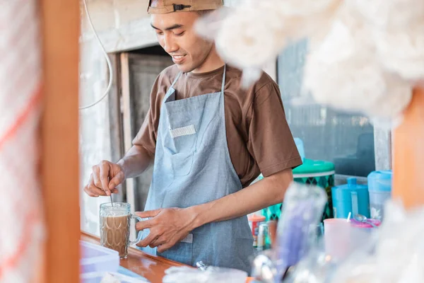 アジアの男の売り手は、顧客のための飲み物を作るエプロンのカートストール — ストック写真