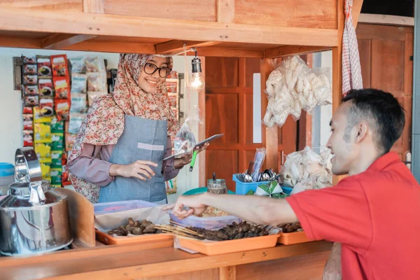 Hijab vendedor mulher a loja de carrinho sorri usando tablet pc ao servir o cliente — Fotografia de Stock
