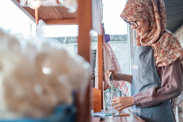 Dívka v hidžábu prodejce nalije balíček mléka, aby nápoj — Stock fotografie