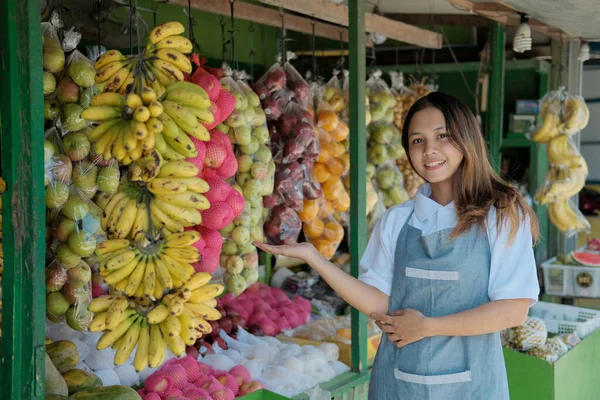 Kobieta stojąca obok organicznych owoców w boksie — Zdjęcie stockowe
