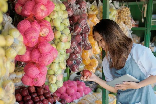 Zbliżenie się kobieta sklep asystent za pomocą tablet w jego sklep z owocami — Zdjęcie stockowe