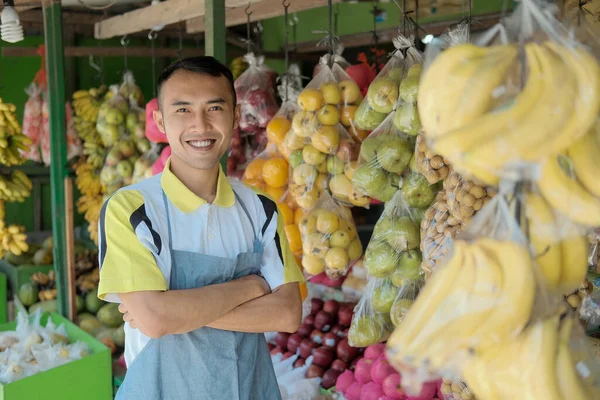 Waist up portrait of handsome young man working in fruits shop