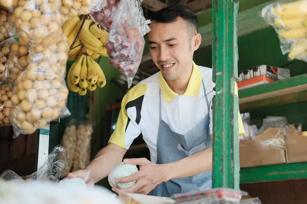 Молодой одинокий человек работает в фруктовом магазине — стоковое фото