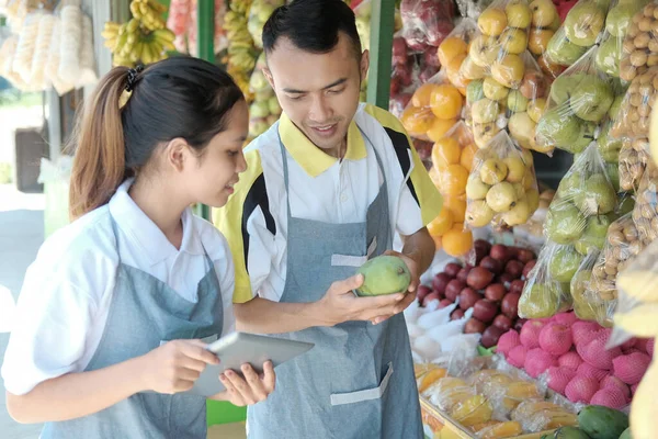 亚洲夫妇使用垫子经营新鲜有机水果店 — 图库照片