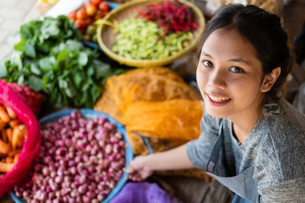 Top side view of a beautiful Asian greengrocer holding a tray — Stock Photo, Image