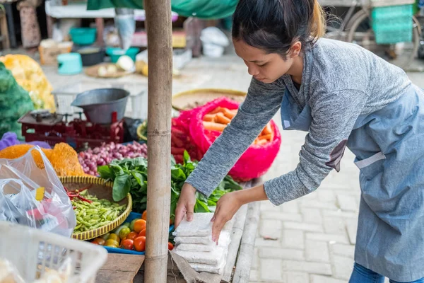 Ázsiai nő zöldséges lehajolt, hogy gondoskodjon tempeh egy növényi standon — Stock Fotó