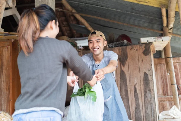 Улыбающиеся мужчины с пластиковыми пакетами, подаренными покупательнице — стоковое фото