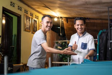 Asyalı erkekler başparmakları havada müşterilerle görüştüğünde gülümserler iyi bir ekran yazıcıdan memnun olurlar