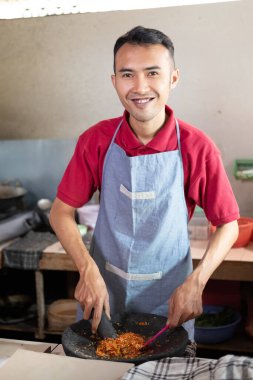 Aşçı yemek pişirmek için havan topuna baharatları sererken gülümsedi.