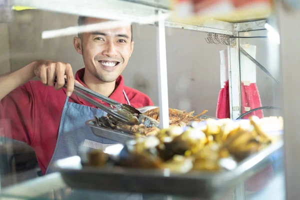 O garçom asiático sorridente leva o frango frito na bandeja de ferro — Fotografia de Stock