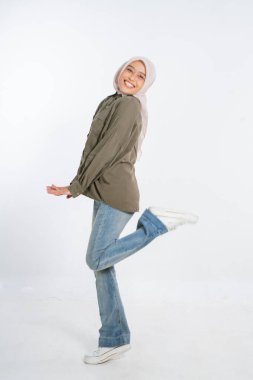 Neşeli genç bir kadın şık bir kıyafet içinde neşeli ve hayat dolu bir poz veriyor.