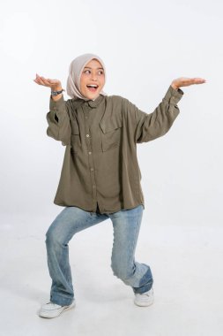 Neşeli ve neşeli genç bir kadın rahat ve modaya uygun kıyafetler giyerken neşeli poz verir.