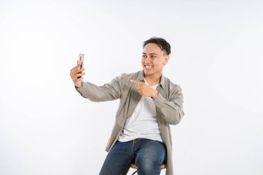 Neşeli bir adam akıllı telefon cihazıyla selfie çekerken keyifli bir anın tadını çıkarıyor.