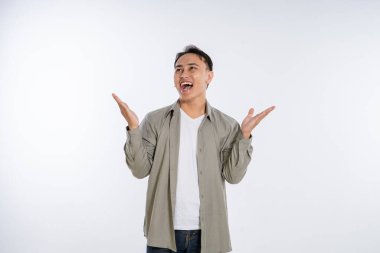 Genç bir adam canlı bir stüdyo ortamında neşeli bir poz sergilerken heyecandan patlıyor.