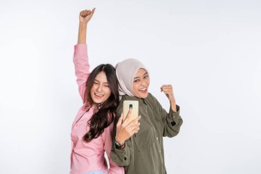 İki arkadaş mutlu bir şekilde poz veriyor, harika ve mutlu bir anı paylaşıyorlar.