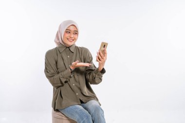 Genç bir kadın mutlu bir şekilde akıllı telefonunu kullanır, mutluluk saçar ve derin bir ilişki yaşar.