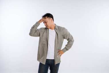 Genç bir adam derin hayal kırıklığını açıkça ifade eder, elini alnına koyar.