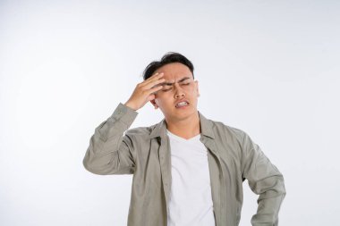 Asgari bir ortamda hayal kırıklığı ve stres belirtileri gösteren genç bir adam.