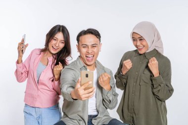 Gülümseme ve kahkahalarla dolu neşeli bir selfie çeken üç arkadaş.