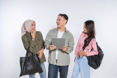 Neşeli bir arkadaş grubu, birlikte tablete bakarken neşeyle etkileşime geçiyorlar.