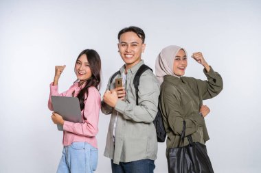 Bir grup genç yetişkin akademik başarılarını neşeyle kutluyor.