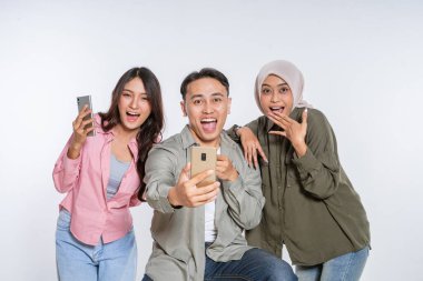 Üç yakın arkadaş mutlu bir şekilde spontane bir selfie çeker ve güçlü bağlarını gösterirler.