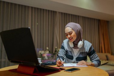 Kendini işine adamış bir bayan öğrenci evdeki online öğrenme deneyimine derinden bağlıdır.