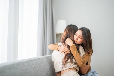 Çağdaş ve rahat bir ortamda, iki kadın sıcak ve samimi bir kucaklaşmayı paylaşıyor.