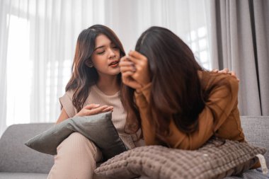 İki arkadaş samimi bir anı paylaşıyor, samimi bir mekanda duygusal destek sağlıyor..