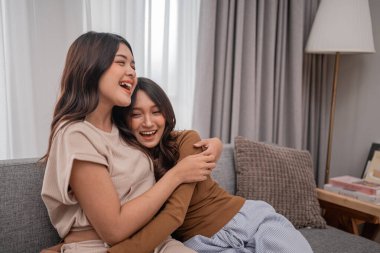 İki neşeli arkadaş, rahat ve şık bir yaşam alanında sıcak bir kucaklaşmayı paylaşıyor.