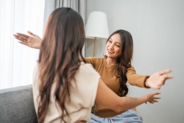 İki yakın arkadaş evdeyken sıcak bir kucaklaşmayı ve kahkahayı paylaşıyorlar.