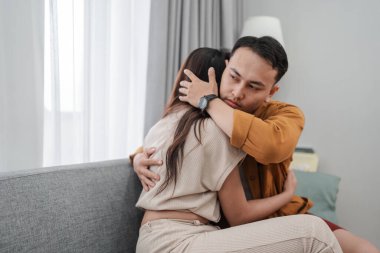 Samimi bir kucaklaşmayı paylaşan, samimi bir ortamda duygusal destek veren bir çift..