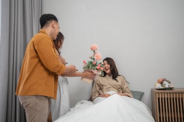 Arkadaşlar, sıcak bir iç mekanda güzel çiçeklerle gelinlerine sevinçle sürpriz yaparlar.