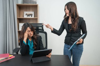 İki bayan meslektaşı, mesleki ilişkilerini gererek iş yerinde gerginlik yaşıyor.