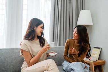 Dostlar sıcak, sıcak bir oturma odasında kahve içerek bir anı paylaşırlar.