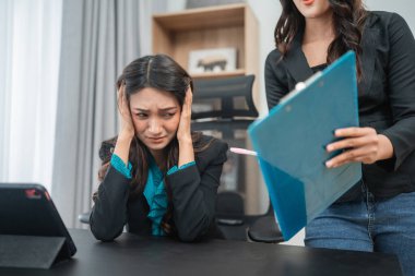 Gergin bir ofis sahnesinde, ezilen bir çalışan iş yerinde büyük baskı ve stresle karşılaşır.