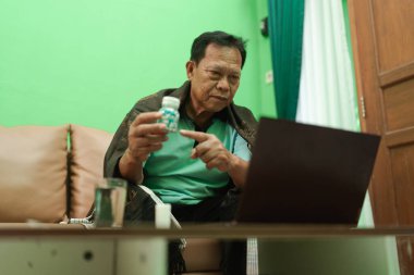 Yaşlı bir adam, daha iyi sağlık hizmetleri erişimi için evden sanal sağlık danışmanlığı yapmaktadır.