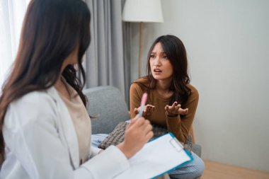 Bir kadın, terapi seansı sırasında duygularını şefkatli bir terapistle paylaşır.