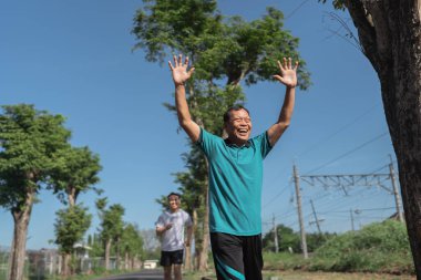 İki hevesli koşucu neşeli bir şekilde açık havayı kucaklıyor enerji ve tutkuyla.