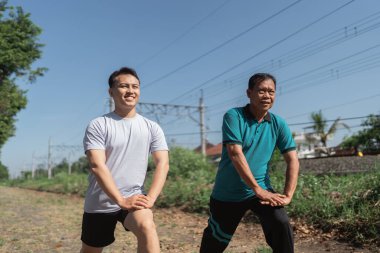 Açık havada esneme egzersizlerine katılan bir grup erkek genel fitness seviyelerini arttırmak için