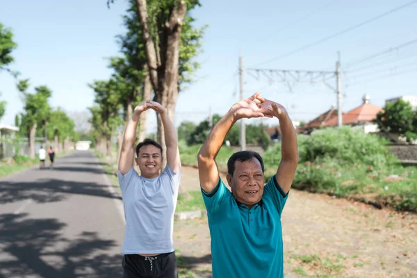 İki erkek birlikte dışarı çıkıyor, spor yapmayı ve doğal güzelliği teşvik ediyor.