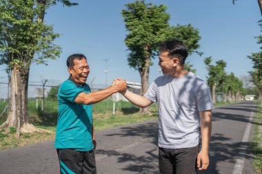 Doğadaki canlandırıcı sabah egzersizlerinden sonra iki adam keyifli bir beşliği paylaşıyor.